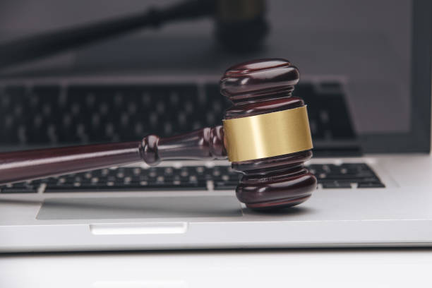 Closeup of laptop and mallet on table in courtroom gavel on white laptop. Concept -online Auction gavel keyboard stock pictures, royalty-free photos & images