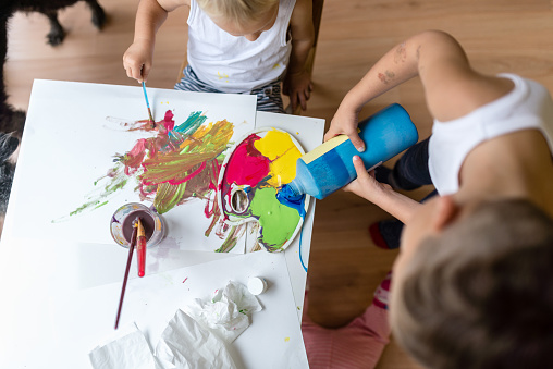 High angle view of children playing with colorful paints.