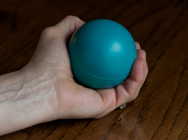 istock Senior Woman with Stress Ball Exercising Her Hand on Table 1220634041