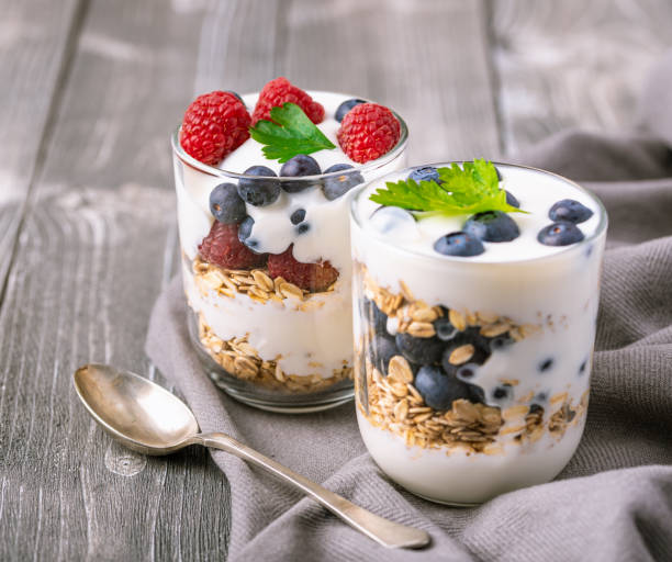 istock White yogurt in glass jar with fruits on grey background. 1220634320