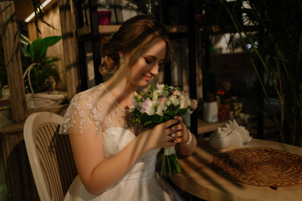 istock Snow bride holds a bouquet in her hands sniffs his eyes closed. photo session before the wedding ceremony. 1220635319