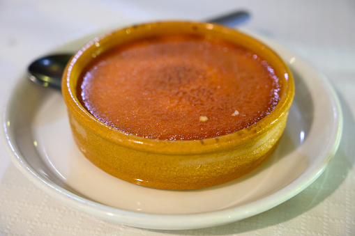 Sweet Spanish dessert, caramelised crema catalana in clay bowl close up