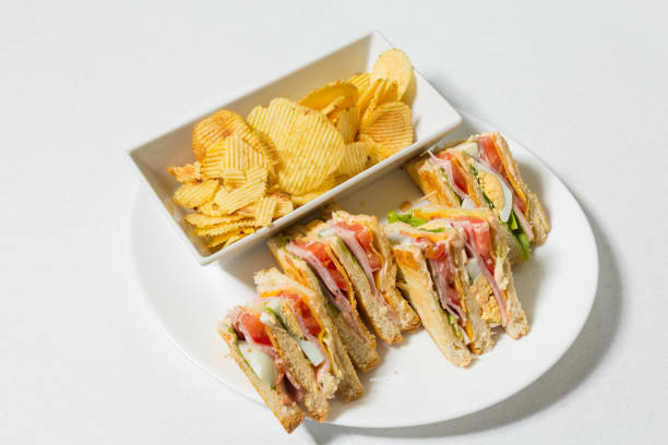 sandwich club servito su un piatto con patatine fritte - sandwich turkey potato chip plate foto e immagini stock