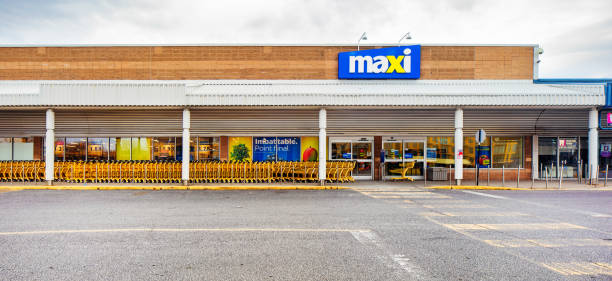 Maxi Supermarket facade panoramic view on a cloudy day Maxi Supermarket facade panoramic view on a cloudy day with a long line of empty carts. Photographed in Montreal on Easter day during Covid lockdown. Maxi is the discount brand of Loblaw's grocery stores. maxi length stock pictures, royalty-free photos & images