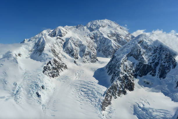 Mount Denali, or MtMcKinley, Alaska USA Mount Denali (formerly Mount McKinley) rises in the Alaska Range. With an elevation of 20,310 feet (6,190 m) above sea level this is the highest peak in North America. Mountains around form part of the Denali National Park. Photograph taken from the South-West on a sunny, summer day. denali mountain stock pictures, royalty-free photos & images