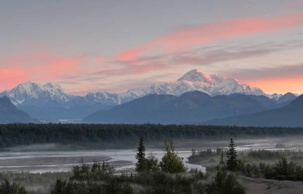 Denali dawn, Alaska Mount Denali (former Mt McKinley) at sunrise seen from the Parks Highway in Central Alaska. With an elevation of 20,310 feet (6,190 m) above sea level this is the highest peak in North America. Mount Hunter to the right. Mountains around form part of the Denali National Park with Chulitna River flowing in the valley. denali mountain stock pictures, royalty-free photos & images