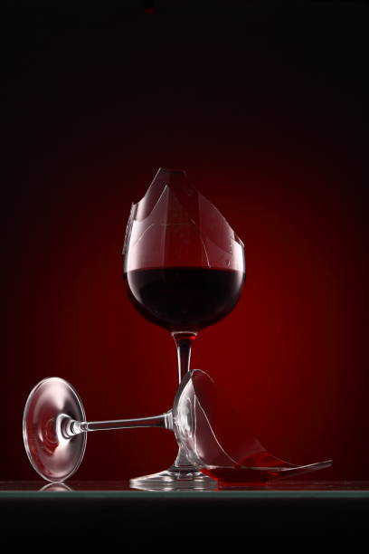 copa de vino roto con vino sobre un fondo de color rojo oscuro - glass broken spilling drink fotografías e imágenes de stock