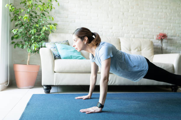 istock Focused woman doing a plank at home 1220640271