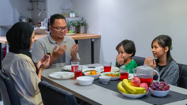 istock Family praying before having dinner at home 1220640449