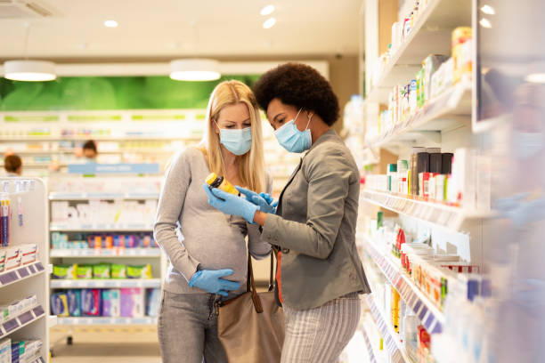 mujer embarazada de compras en casa de farmacia con amigo durante el brote de virus corona. - pill human pregnancy capsule women fotografías e imágenes de stock