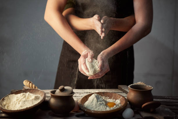 istock Concept woman with many hands speaks from flour dough, on the kitchen table. 1220642018