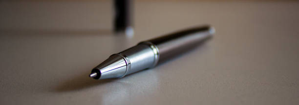 istock Beautiful dark pen with cap on grey office table. Concept. 1220643991