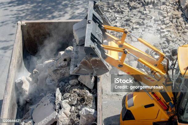 Bulldozer Loader Uploading Concrete Debris Into Dump Truck Stock Photo - Download Image Now