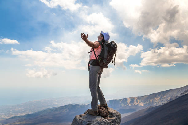istock Man with open arms while climbing Mount Etna, Italy. 1220647302