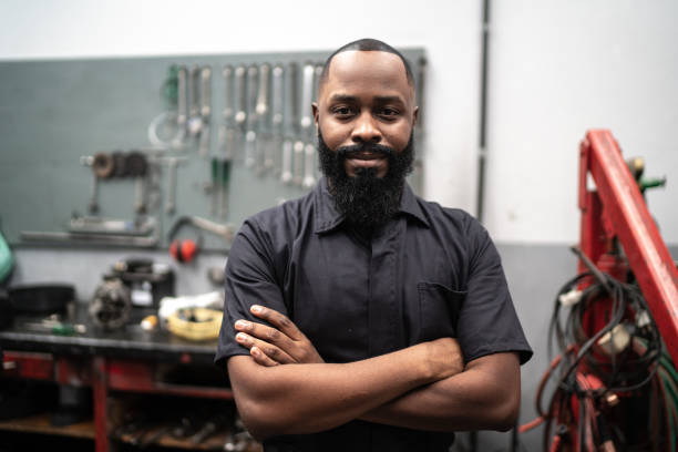 retrato de mecânico com braços cruzados em reparo de automóveis - coveralls professional occupation manual worker service occupation - fotografias e filmes do acervo