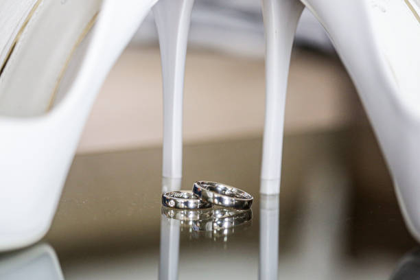 A selective focus of white bridal shoes with wedding rings