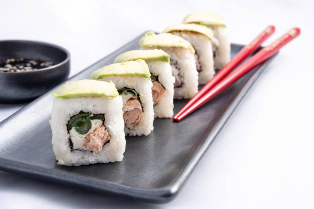 sushi roll with avocado wrap, grilled salmon, philadelphia cheese and green onions black container and red chopsticks - fine dining grilled spring onion healthy lifestyle imagens e fotografias de stock