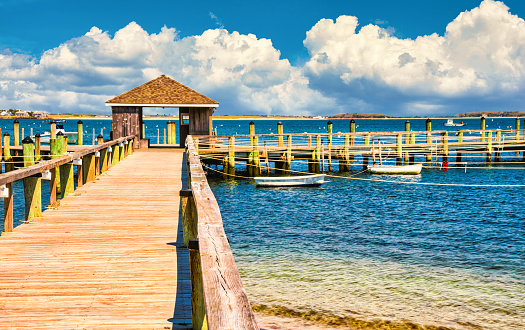 Long wooden pier on the blue tropical windy sea