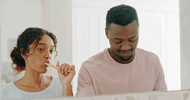 We're about to give the world our best smiles Cropped shot of a happy young couple brushing their teeth and getting ready together in their bathroom at home brushing teeth stock pictures, royalty-free photos & images