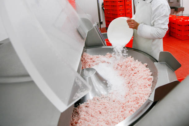 istock A worker at the meat processing factory, adds spices to minced meat in a processing machine. 1220650826
