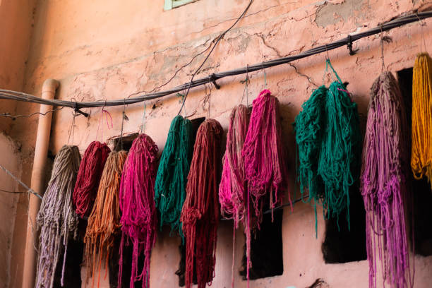 wielobarwne nitki z surowego jedwabiu wiszą po barwionym kolorze w historycznym suku marrakeszu - blue carpet rug fiber zdjęcia i obrazy z banku zdjęć