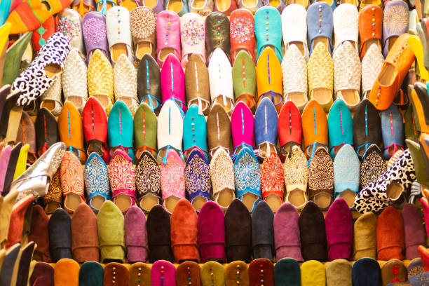 schauige stände mit kunsthandwerkerschuhen im historischen souk von marrrakech - craft market morocco shoe stock-fotos und bilder