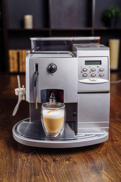 istock Making fresh coffee going out from a coffee espresso machine. Making capuccino in glass transparent coffee cup. Budget coffee maker 1220653378