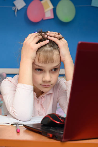 istock Girl can not solve the difficult task of studying online 1220653626