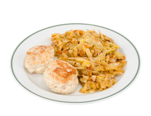 Plate with meat patties and stewed cabbage isolated on white background. Studio Photo