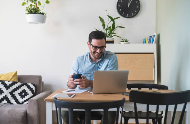 istock Handsome young man working on laptop computer at home stock photo 1220655407
