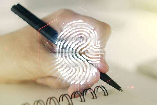 istock Multi exposure of abstract fingerprint scan interface with man hand writing in notepad on background, digital access concept 1220656599