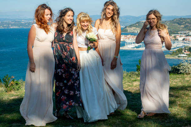 istock Cheerful Bride and Bridesmaids Enjoying Outdoors After Wedding Ceremony 1220657706