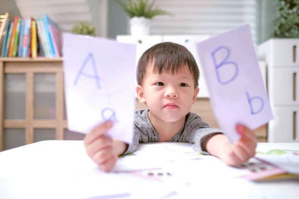 Asian children learning English with flash cards, Teach young kids English at home, Child at home, kindergarten closed during the Covid-19 health crisis stock photo