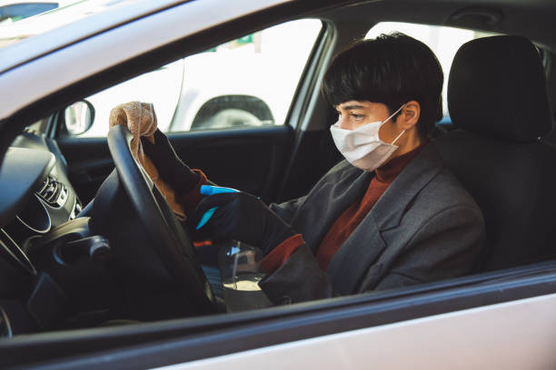 istock Woman sanitizing the car before and after going to work 1220661850