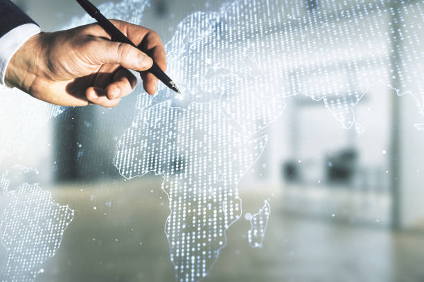 istock Man hand with pen working with abstract creative digital world map on blurred office background, globalization concept. Multiexposure 1220661940
