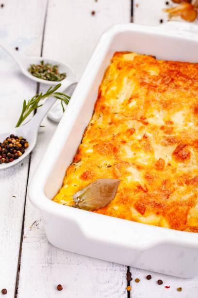 istock Potato gratin in white casserole dish on wooden rustic table. Close up 1220664352
