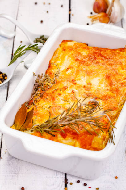 istock Potato gratin in white casserole dish on wooden rustic table. Close up 1220664889