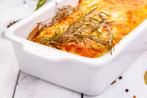istock Potato gratin in white casserole dish on wooden rustic table. Close up 1220664898