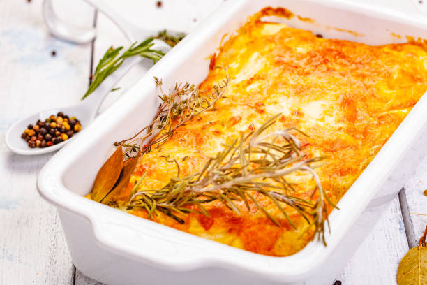 istock Potato gratin in white casserole dish on wooden rustic table. Close up 1220664902
