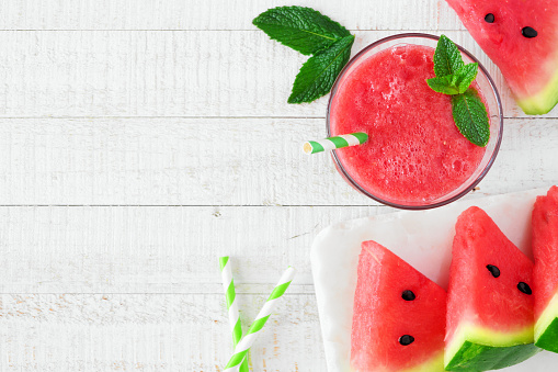Glass of watermelon juice. Top view over a white wood background. Copy space.
