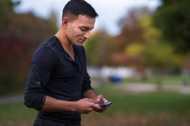 istock Attractive Indian man texting on mobile phone 1220669676