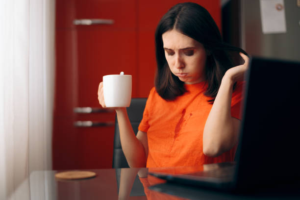 clumsy mujer bebiendo café manchando su camisa - pessimist women one person caucasian fotografías e imágenes de stock