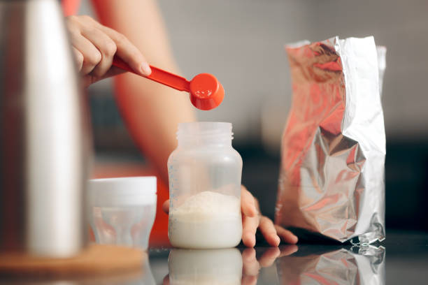 Mom Preparing Formula in Baby Bottle at Home Close up of hands mixing baby food with hot water formula stock pictures, royalty-free photos & images