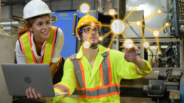 Caucasian male with laptop and mixed race female engineer working in factory area. Caucasian male with laptop and mixed race female engineer working in factory area. trainee training computer designer stock pictures, royalty-free photos & images