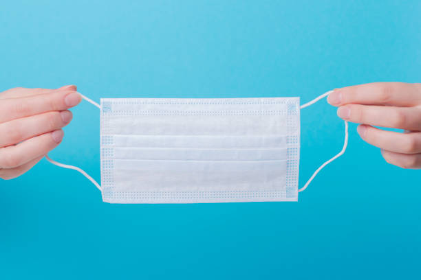 istock Woman hands holding medical mask 1220673698