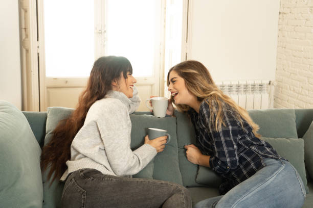 istock COVID-19 lockdown. Confident and optimistic women girlfriends together talking and drinking hot drink staying together at home in isolation. Stay home Stay safe health and safety campaign concept. 1220681006