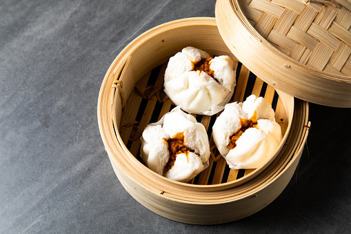 Chinese Traditional cuisine concept. Dumplings Dim Sum in bamboo steamer with text copy space. Asian food background