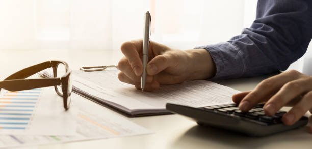 istock Young woman using calculator, calculating finance at workplace, female hands and paper document at table close up, economist or financier writing report, paperwork, student doing homework 1220682784