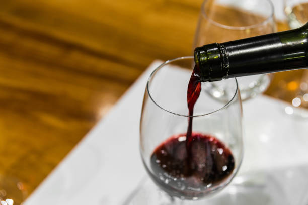 istock A sommelier serving red wine into a wine glass 1220685066