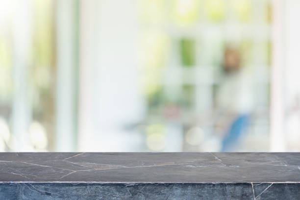 istock Empty black stone marble table top and blurred of interior restaurant with window view green from tree garden background background - can used for display or montage your products. 1220686831